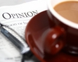 A corner of a newspaper beneath a cup and saucer. 